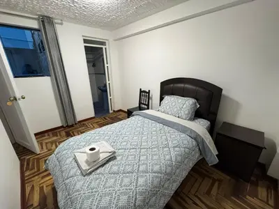 a bedroom with a bed with a tray with a cup on it at Ankay House in Cusco