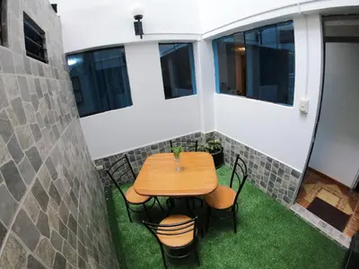 a small patio with a wooden table and chairs at Ankay House in Cusco