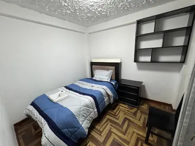 a small bedroom with a bed and a chair at Ankay House in Cusco