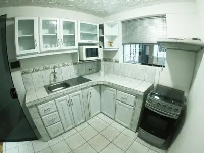 a kitchen with white cabinets and a sink and a stove at Ankay House in Cusco