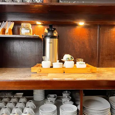 a table with plates and cups and a coffee pot at Hospedaje Turístico - Kantu Inn in Ollantaytambo