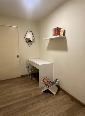 a room with a desk and a shelf with books at Pardo Miraflores Apartment - Aparts 4 Days in Lima