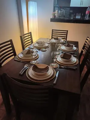 a table with plates and wine glasses on it at casa de playa en lurin con piscina y parrilla in La Planicie
