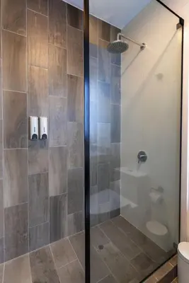 a shower with a glass door in a bathroom at Grimaldo by Geko in Lima