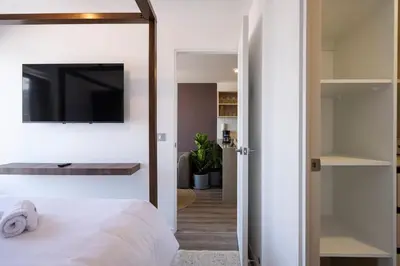 a bedroom with a bed and a tv on a wall at Los Pinos by Geko in Lima