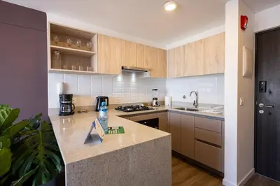 a kitchen with wooden cabinets and a counter top at Los Pinos by Geko in Lima