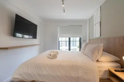 a bedroom with a white bed with a towel on it at Los Pinos by Geko in Lima