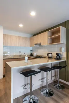 a kitchen with a counter and two bar stools at Los Pinos by Geko in Lima
