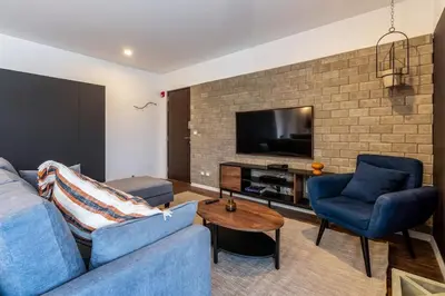 a living room with a couch and two chairs and a television at Dubrovnik 2BR by Geko in Lima