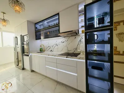 a kitchen with white cabinets and a stainless steel refrigerator at El Palacio del Rey in Lima