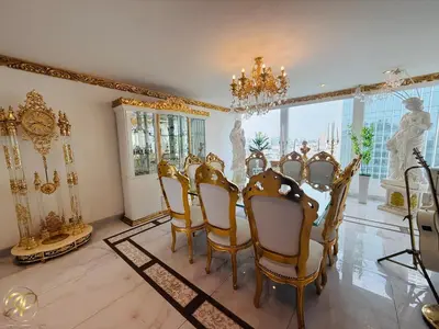 a dining room with a table and chairs and a chandelier at El Palacio del Rey in Lima
