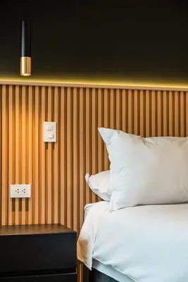a bedroom with a bed and a wooden wall at Vince City 1BR by Geko in Lima