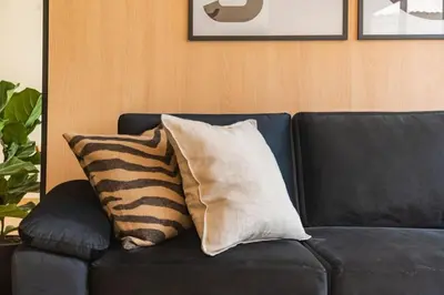 a black couch with two pillows on it at Vince City 1BR by Geko in Lima