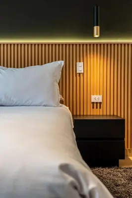 a bedroom with a bed and a wooden wall at Vince City 1BR by Geko in Lima