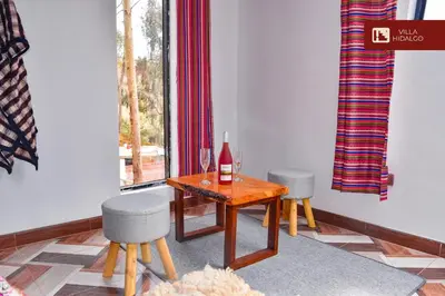 a room with a table with a bottle of wine and two chairs at Villa Hidalgo - Centro Vacacional in Pazos