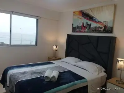 a bedroom with a bed with two pairs of shoes on it at Apartamento en San Miguel hermosa vista al mar in Lima