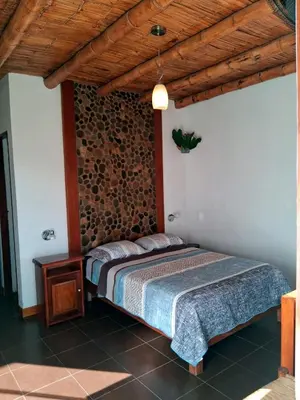 a bedroom with a bed and a wooden ceiling at Punto Sur Lodge - Chincha in Chincha Alta