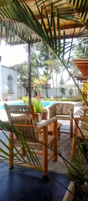 a patio with chairs and a table and a pool at Punto Sur Lodge - Chincha in Chincha Alta