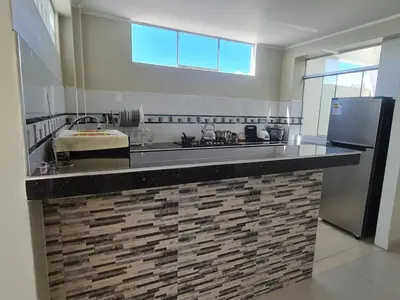 a kitchen with a large counter with a refrigerator at apartment MAGIC in Ayacucho