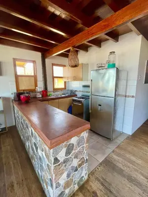 a kitchen with a stone counter and a refrigerator at Casa de playa en Wakama in San Vicente de Cañete