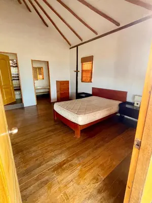 a bedroom with a bed and a wooden floor at Casa de playa en Wakama in San Vicente de Cañete