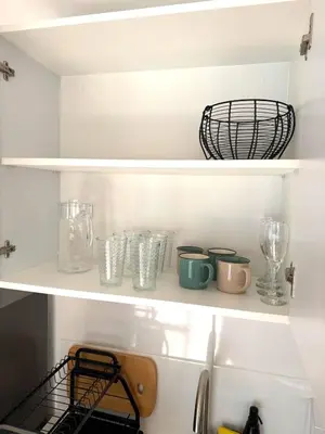 a shelf with dishes and glasses in a refrigerator at Céntrico y acogedor apartamento en Lince in Lima