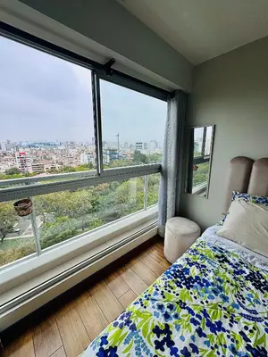 a bedroom with a bed and a large window at Dupli naranjos in Lima