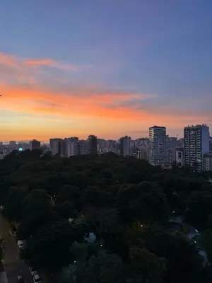 a sunset over a city with trees and buildings at Dupli naranjos in Lima