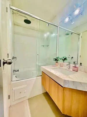 a bathroom with a glass shower and a sink at Dupli naranjos in Lima