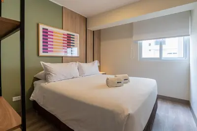 a bedroom with a white bed with a box on it at The Oak 2BR by Geko in Lima