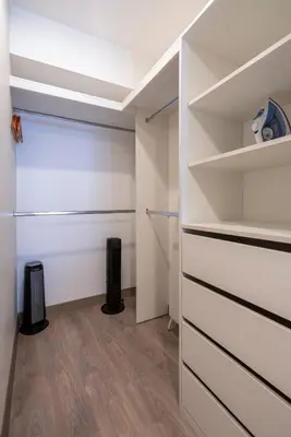 a walk in closet with white walls and wooden floors at The Oak 2BR by Geko in Lima