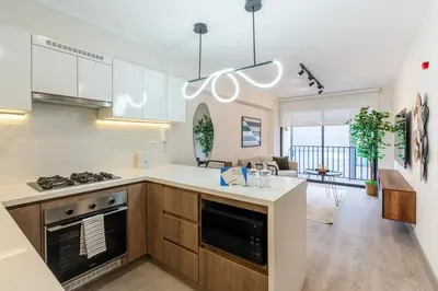 a kitchen with a stove top oven next to a living room at Audiencia by Geko in Lima
