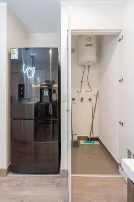 a glass door in a room with a refrigerator at Audiencia by Geko in Lima