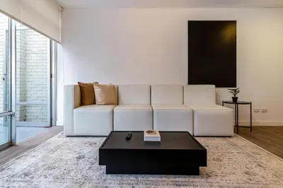 a living room with a white couch and a coffee table at Zebbra 1BR by Geko in Lima