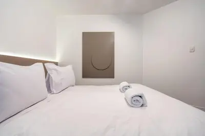a white bed with towels on top of it at Zebbra 1BR by Geko in Lima