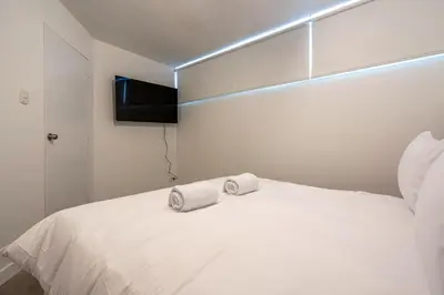 a bedroom with a white bed with two towels on it at Zebbra 1BR by Geko in Lima