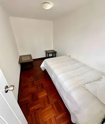 a bedroom with a white bed and a wooden floor at Casa en el corazón de Miraflores in Lima