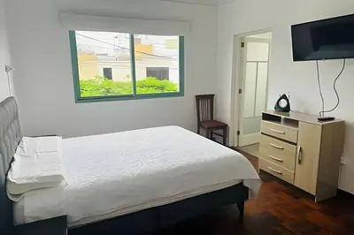 a bedroom with a bed and a flat screen tv at Casa en el corazón de Miraflores in Lima