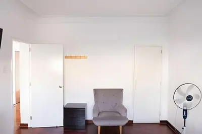 a white room with a chair and a fan at Casa en el corazón de Miraflores in Lima