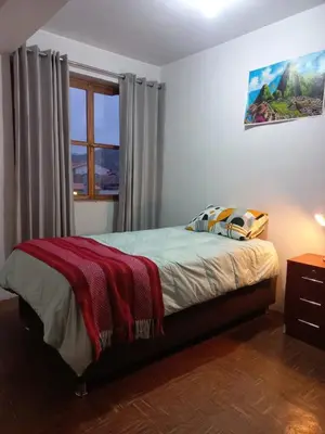 a bedroom with a bed and a window at Posada Escondida in Cusco