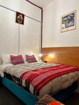 a bedroom with a bed with red pillows on it at Posada Escondida in Cusco