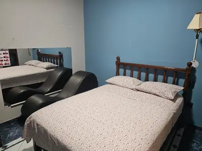 a room with two beds and two chairs in it at Hotel Atenas in Lima
