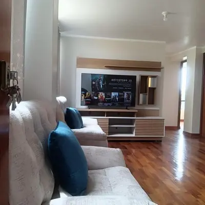 a living room with a couch and a flat screen tv at Bonito Departamento Lima Carabayllo in Lima