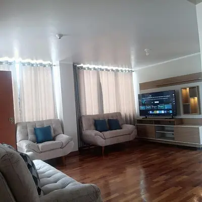 a living room with two couches and a flat screen tv at Bonito Departamento Lima Carabayllo in Lima