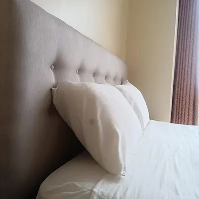 a bed with white pillows on it in a bedroom at Bonito Departamento Lima Carabayllo in Lima