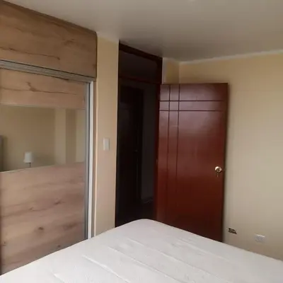 a bedroom with a bed and a closet and a mirror at Bonito Departamento Lima Carabayllo in Lima