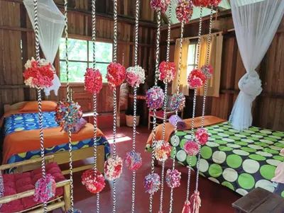 a bedroom with a bed with red and pink flowers at Bella Victoria Ecolodge in Santa María