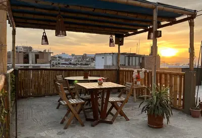 a patio with a table and chairs on a balcony at Paracas Ayni in Paracas