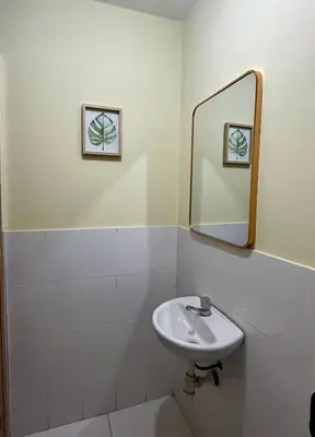 a white bathroom with a sink and a mirror at Paracas Ayni in Paracas