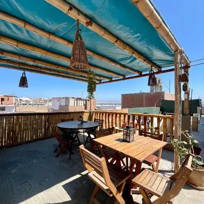a patio with a table and chairs on a deck at Paracas Ayni in Paracas